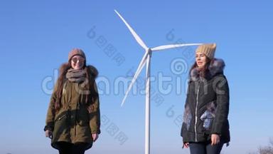 能量转换，快乐的朋友在蓝天的风力涡轮机附近玩得开心